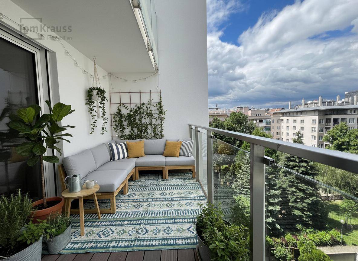 Heller Balkon mit bequemen Outdoor-Möbeln und vielen Pflanzen, bietet einen schönen Blick ins Grüne.