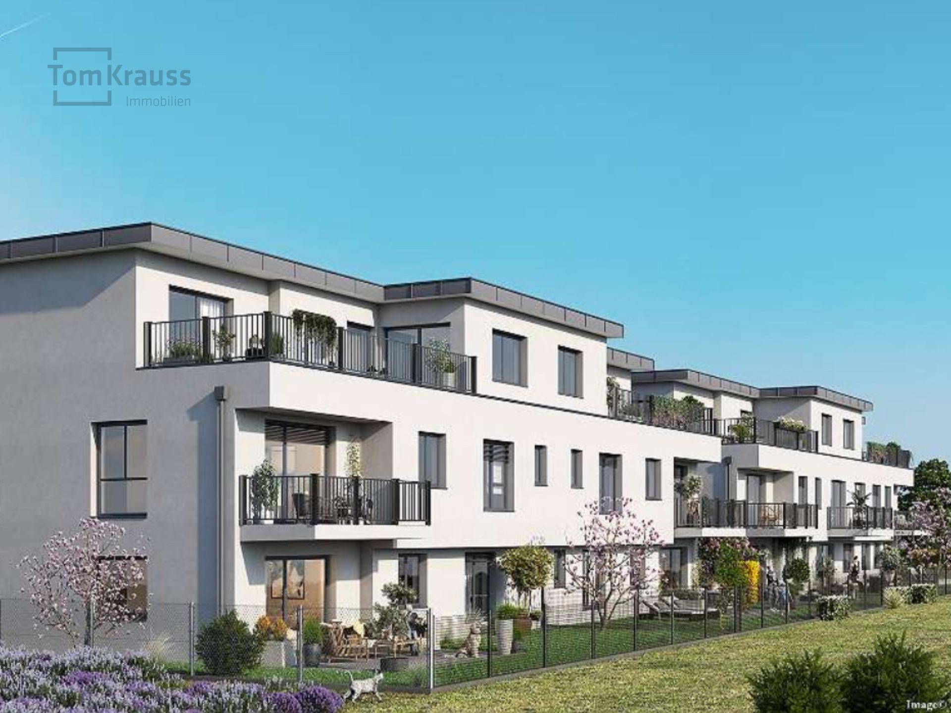 Moderne Wohnanlage mit mehreren Balkonen und Terrassen in grüner Umgebung.