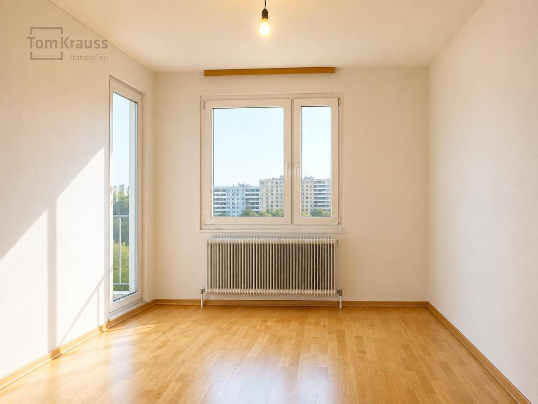 Helles, leeres Wohnzimmer mit Holzboden und großem Fenster mit Stadtblick.