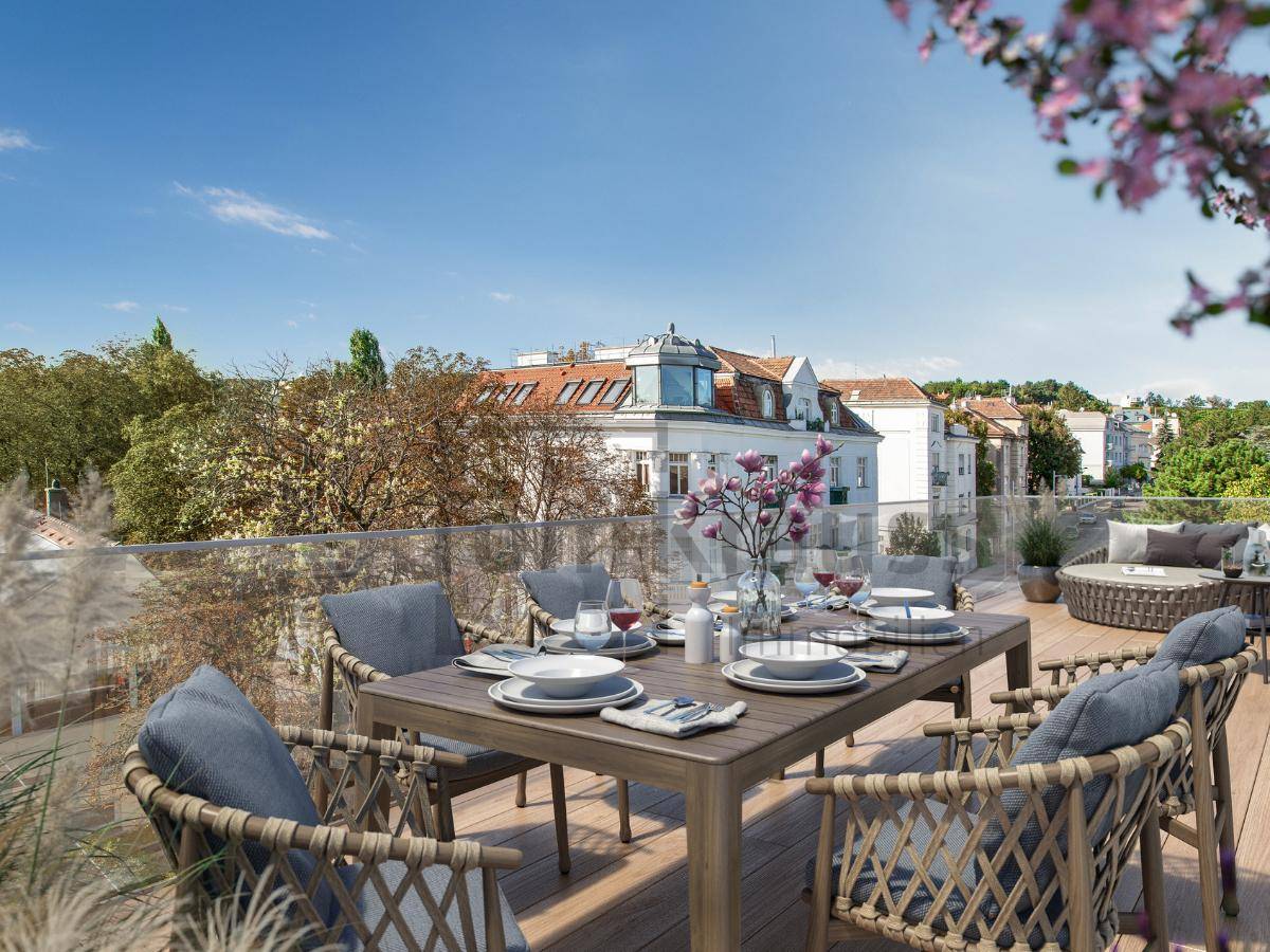 Dachterrasse mit Esstisch und Stühlen, umgeben von Stadtblick und grünen Bäumen.