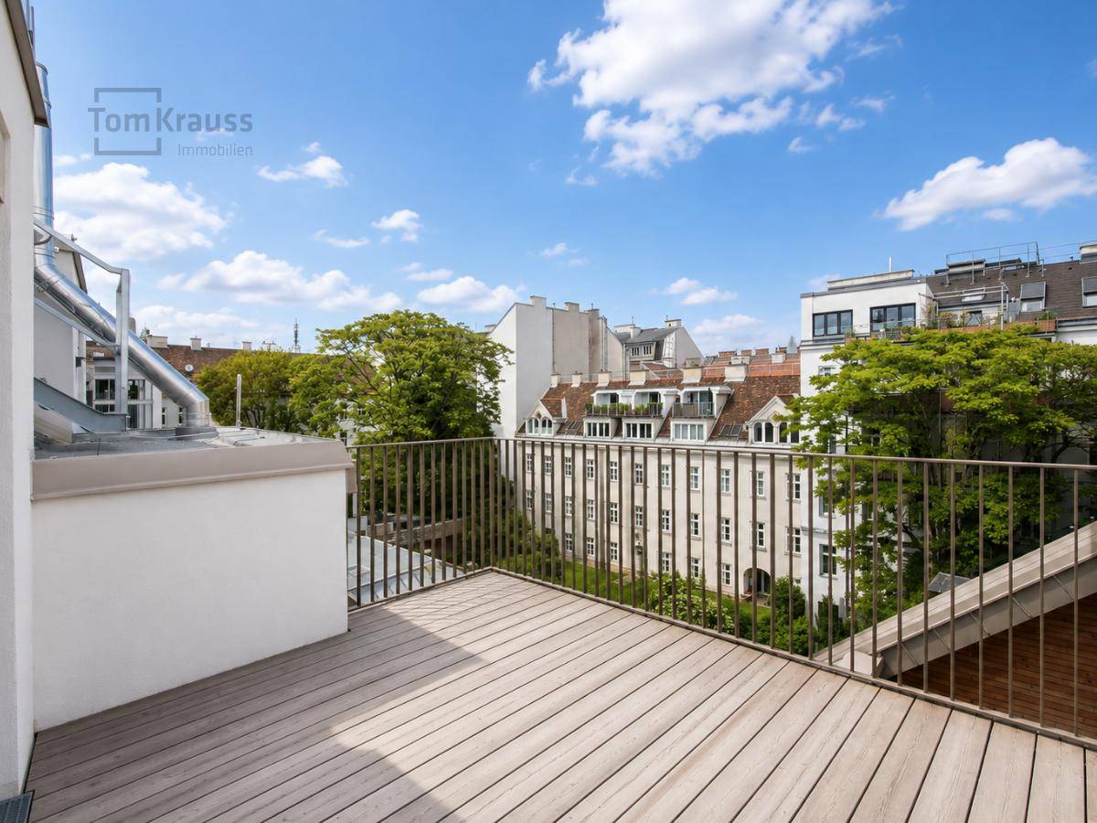 Geräumiger Balkon mit Holzdeck und Metallgeländer bietet einen weiten Blick über die Stadt.