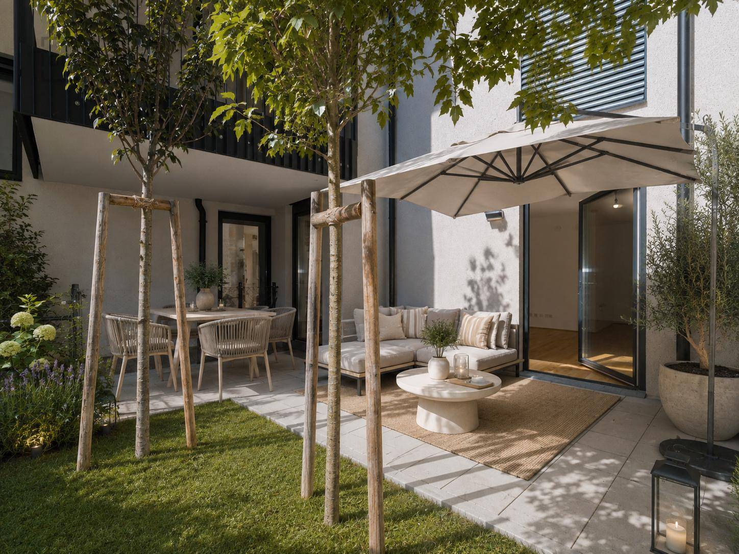 Gemütlicher Gartenbereich mit möblierter Terrasse, Sonnenschirm und jungen Bäumen, ideal zum Entspannen im Freien.