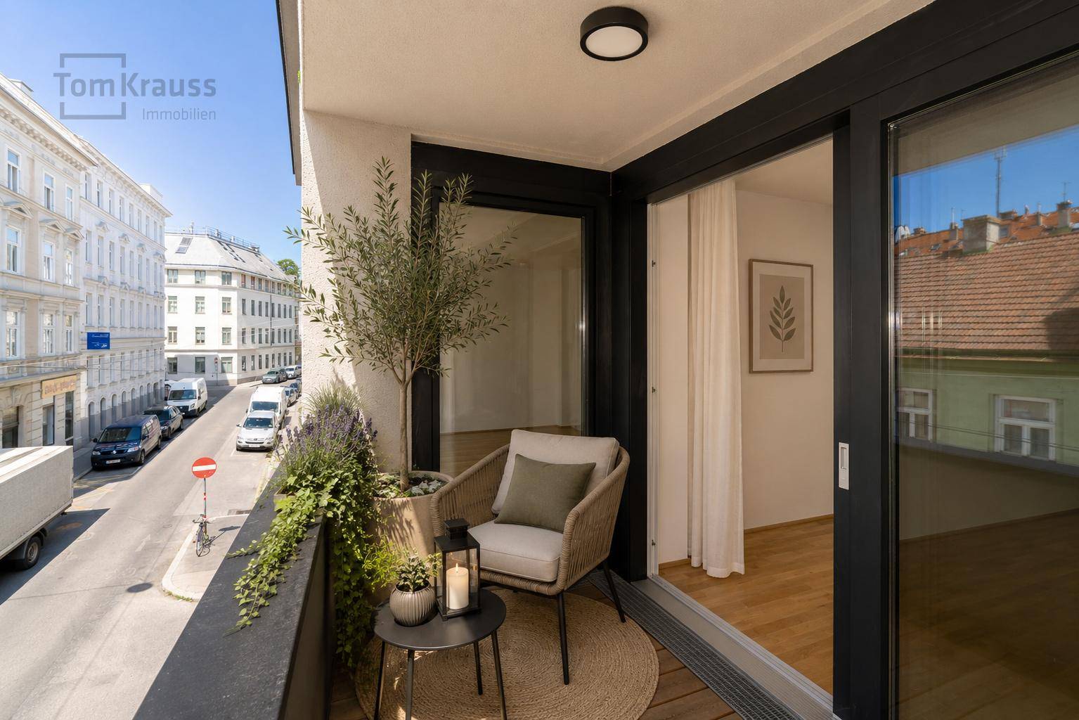 Gemütlicher Balkon mit Sitzgelegenheiten und Pflanzen, bietet einen Blick auf die belebte Straße.