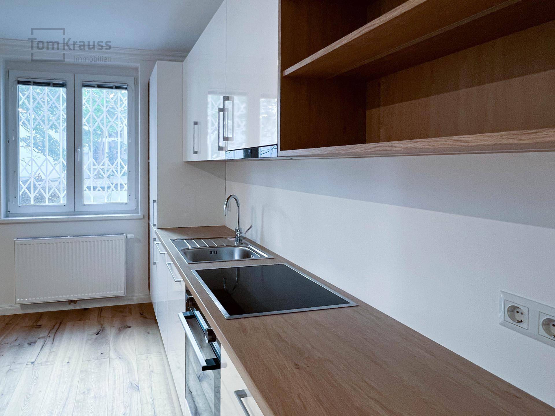 Detailansicht der modernen Einbauküche mit Induktionskochfeld und Holz-Arbeitsplatte.