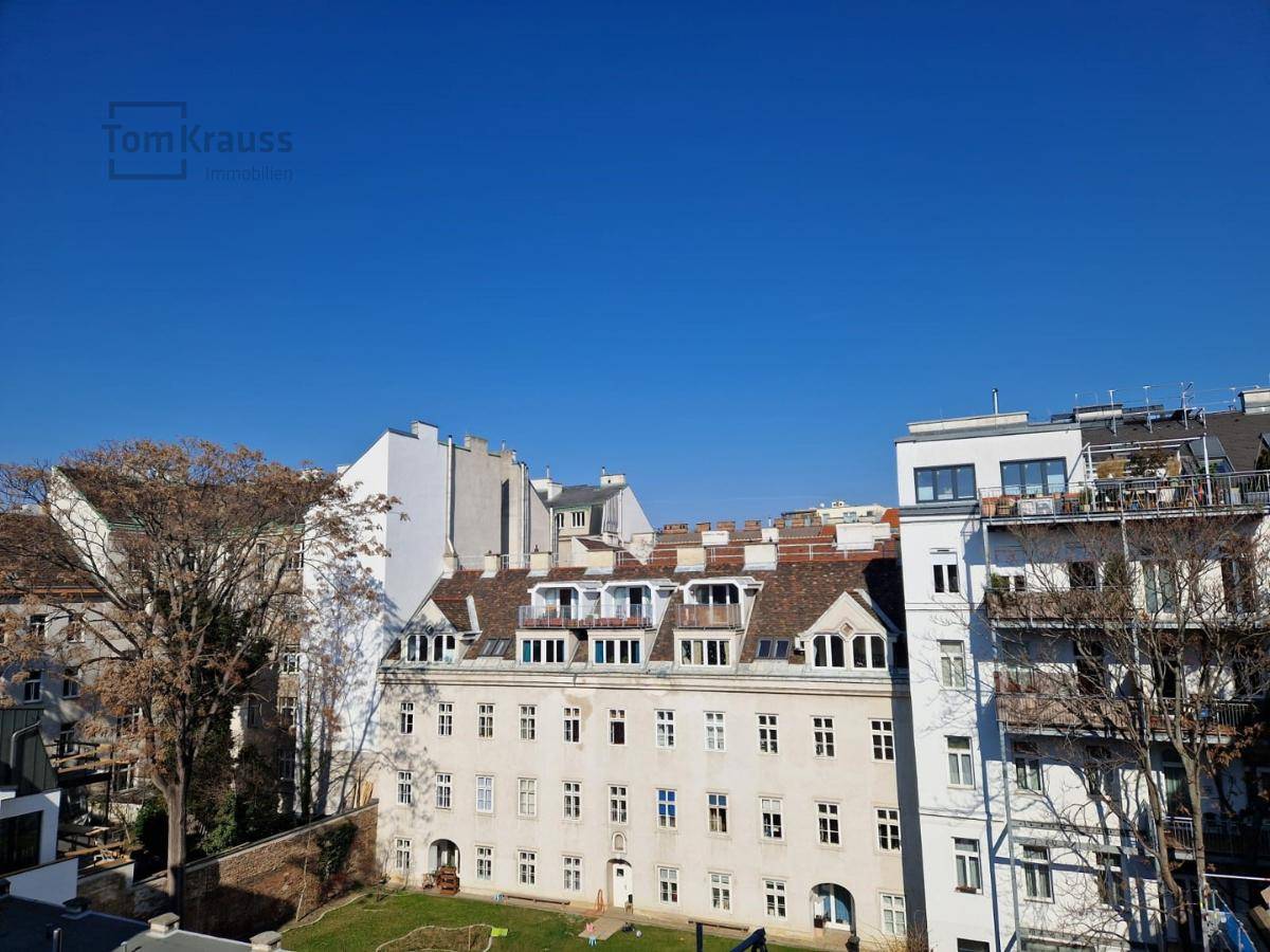 Klarer Blick über die Stadt mit historischen Gebäuden und kahlen Bäumen an einem sonnigen Tag.