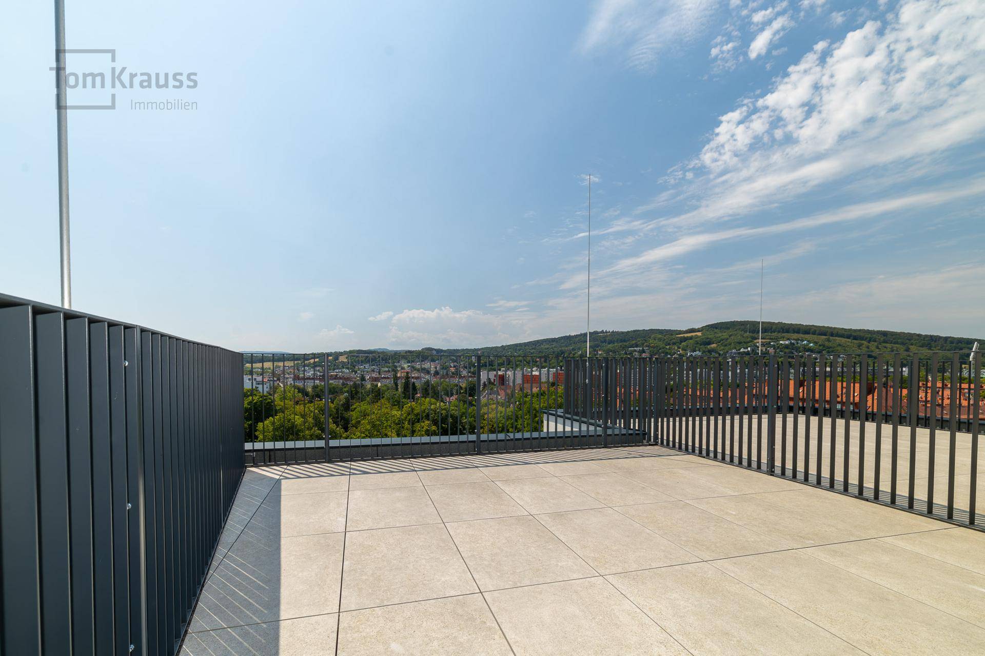 Offene Dachterrasse mit weitem Blick über die Stadt und die umliegende Landschaft.