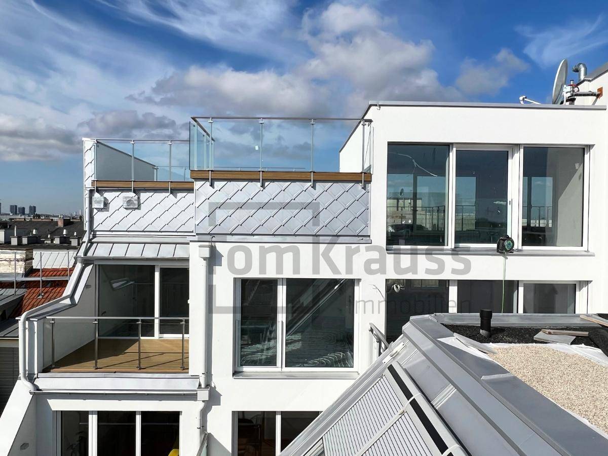 Ansicht der modernen Fassade mit Glasgeländern und großen Fenstern, teilweise im Bau.