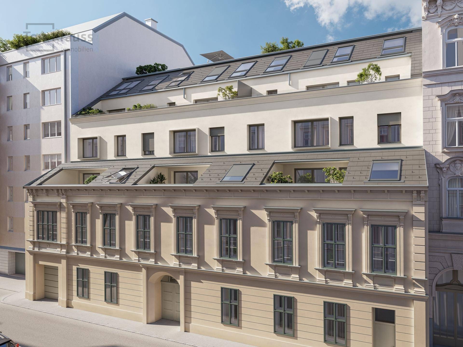Historische Fassade mit modernem Dachausbau und vielen Dachfenstern an einer Stadtstraße.