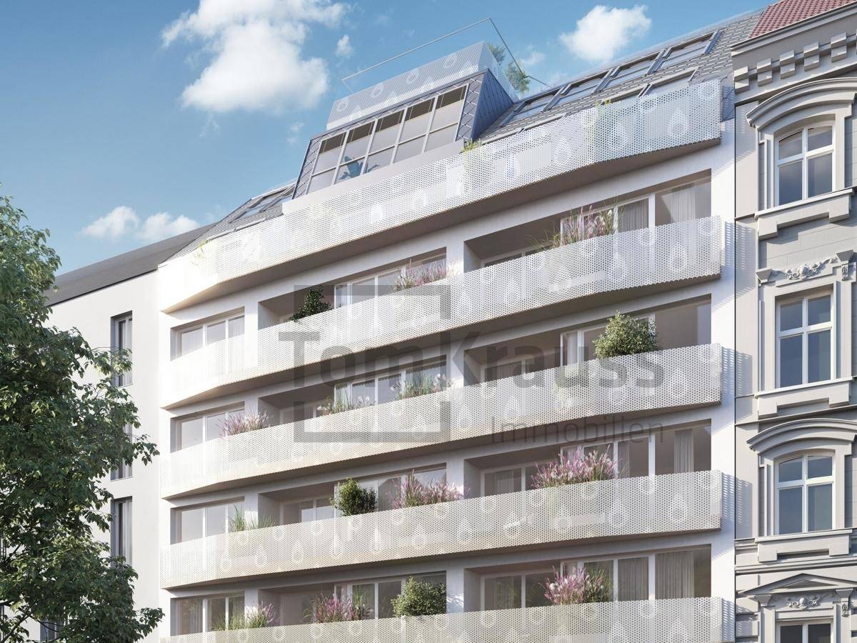 Moderne Gebäudefassade mit perforierten Balkonbrüstungen und vielen Fenstern.