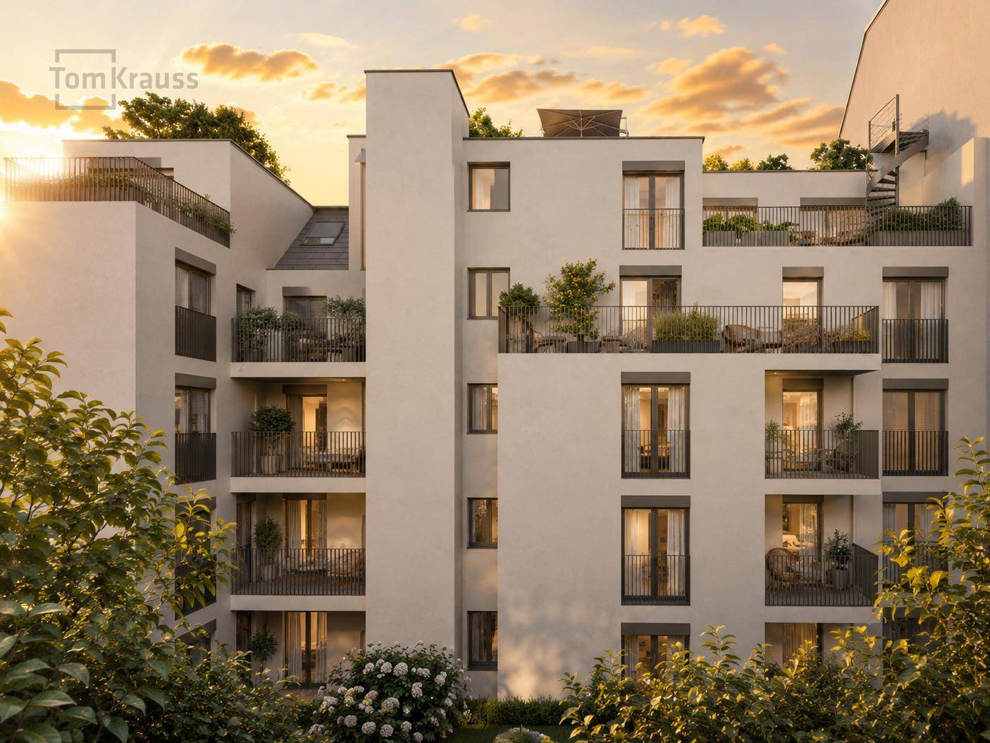 Moderne Wohnanlage mit Balkonen und Terrassen im warmen Licht des Sonnenuntergangs.