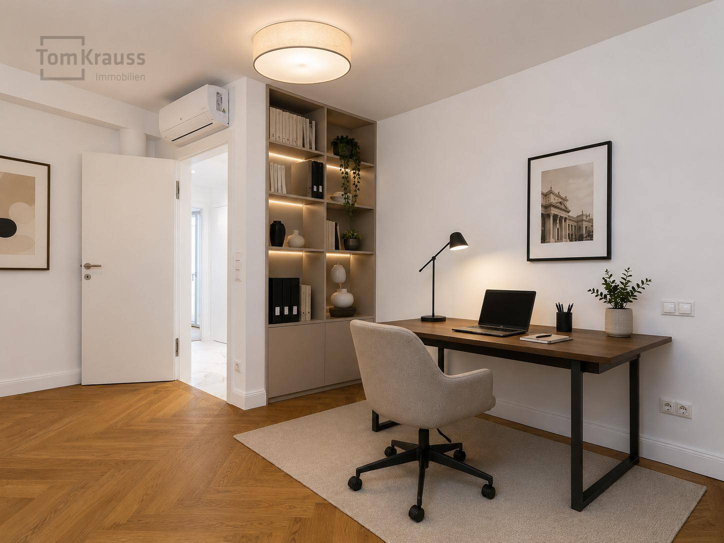 Modernes Arbeitszimmer mit Schreibtisch, Bücherregal und Klimaanlage.