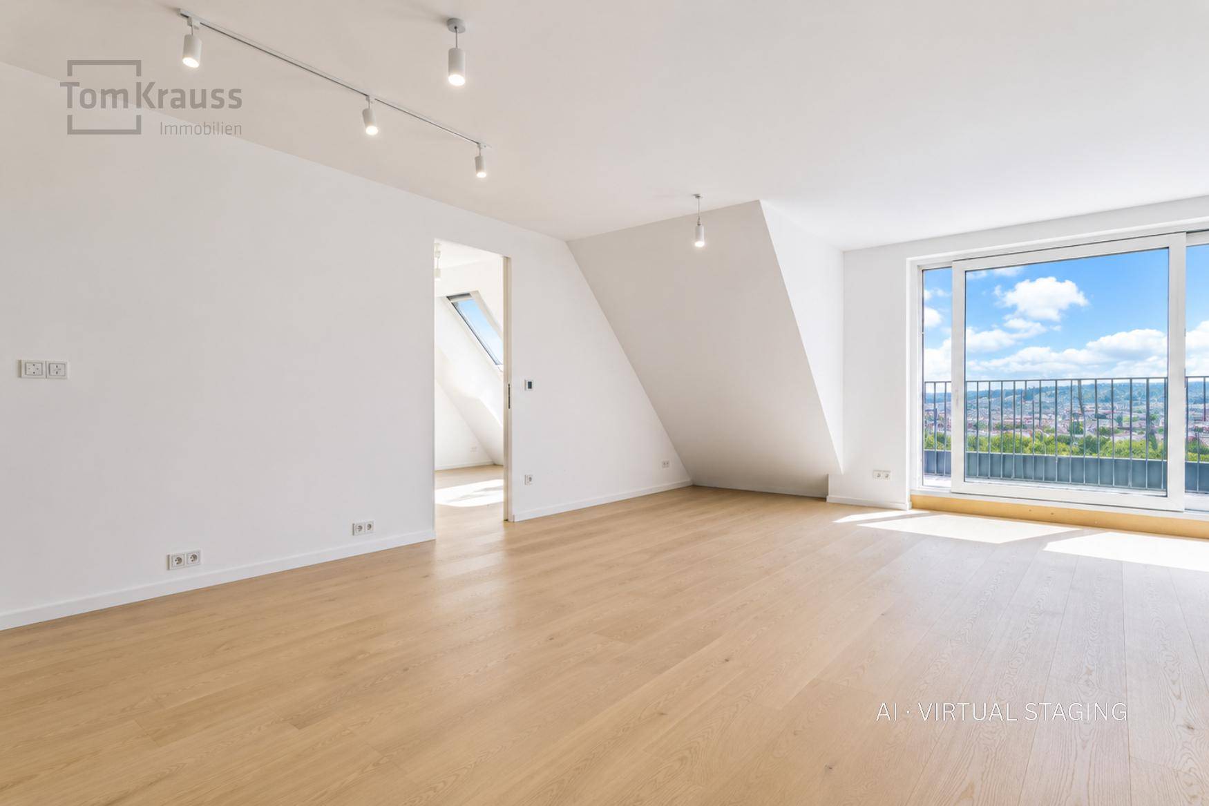 Geräumiger Wohnbereich mit Holzboden, hohen Decken und Zugang zum Balkon mit Aussicht.
