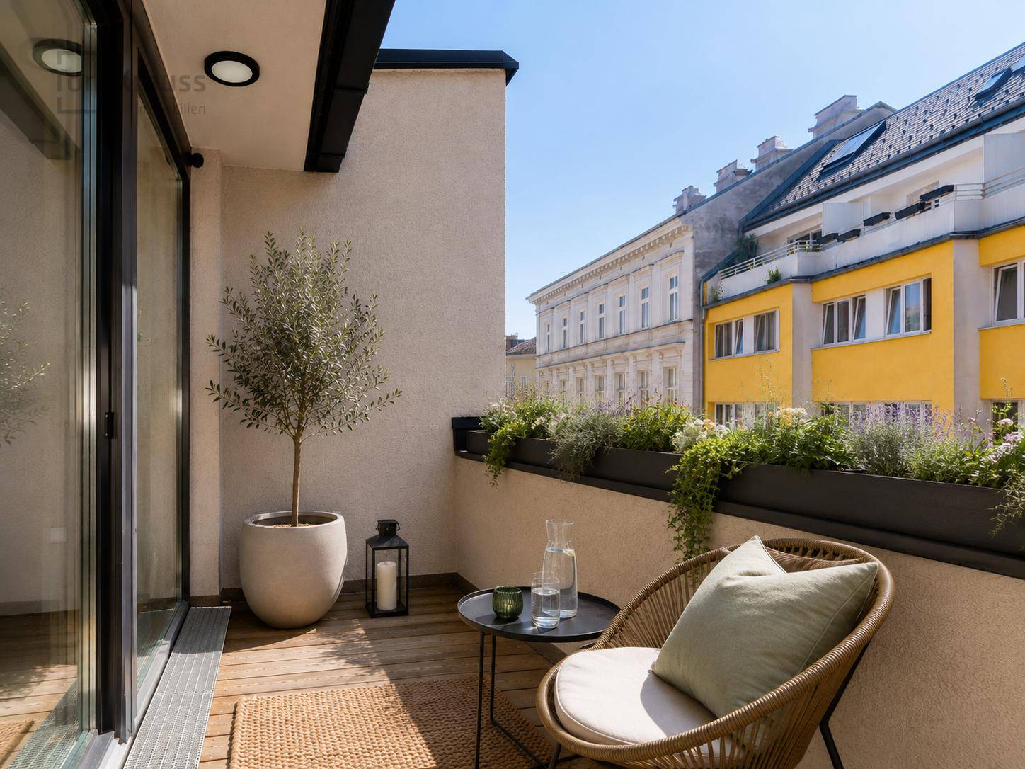 Gemütlicher Balkon mit Holzboden, Sitzgelegenheiten und Blick auf die Stadt.