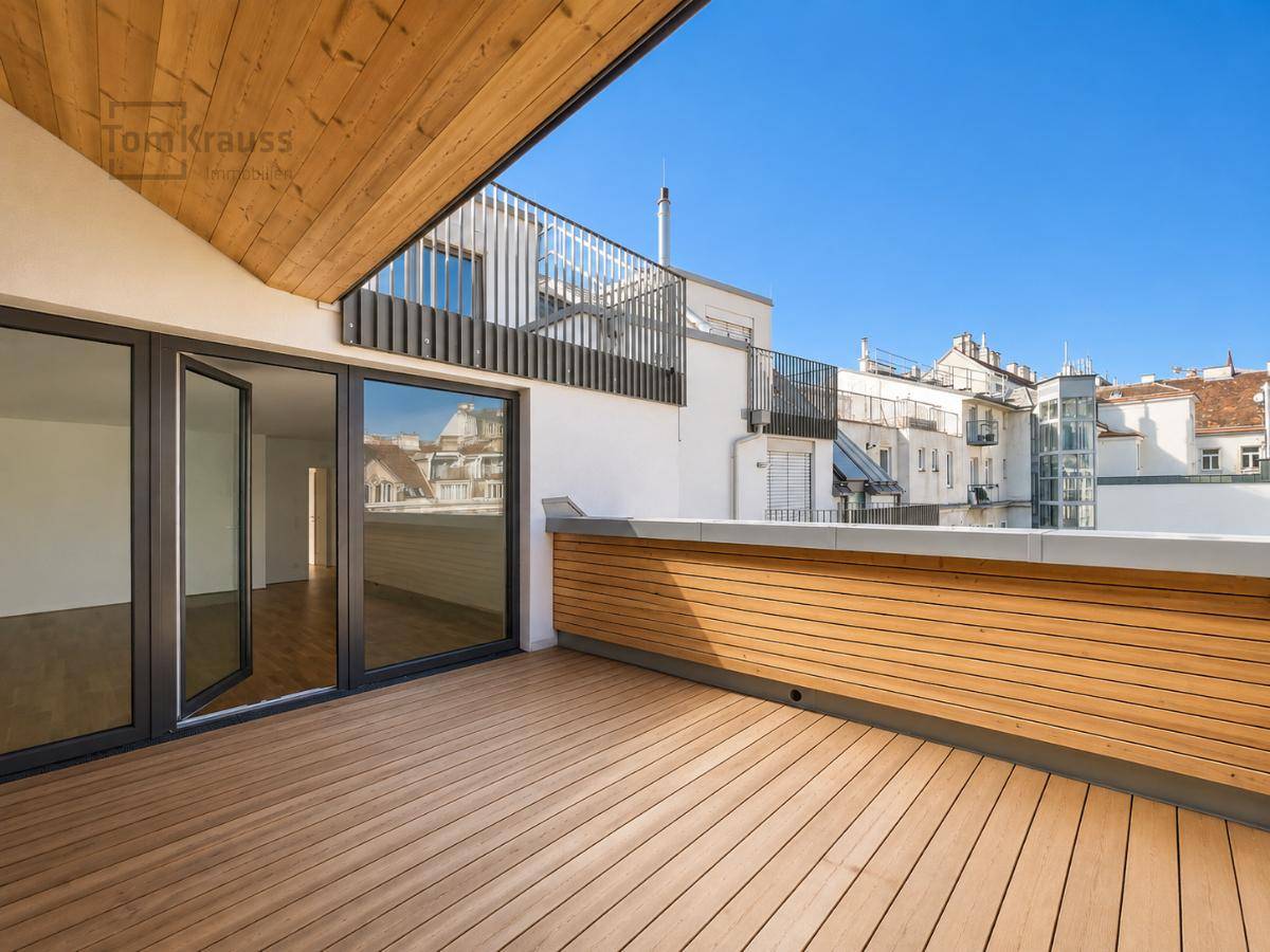 Sonnige Dachterrasse mit Holzboden und Zugang zu den Innenräumen, bietet Stadtblick.