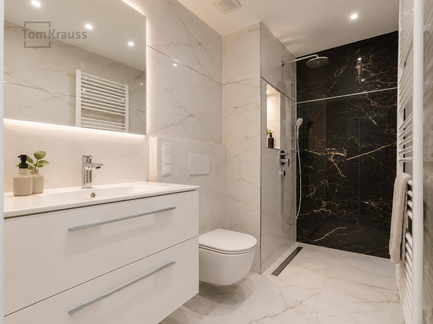 Modernes Badezimmer mit Marmorfliesen, ebenerdiger Dusche und beheiztem Handtuchhalter.