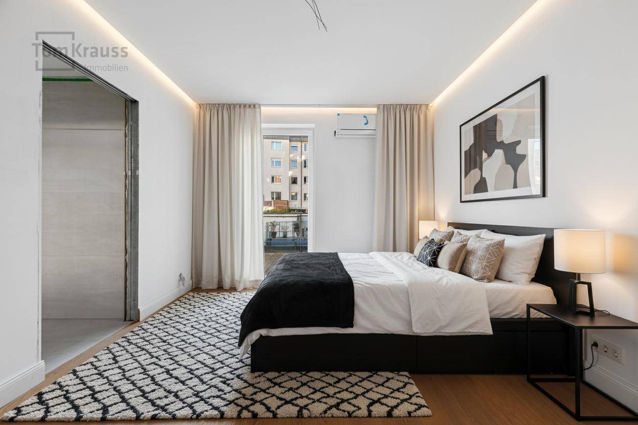 Modernes Schlafzimmer mit Holzboden, indirekter Beleuchtung und Zugang zu einem kleinen Balkon.