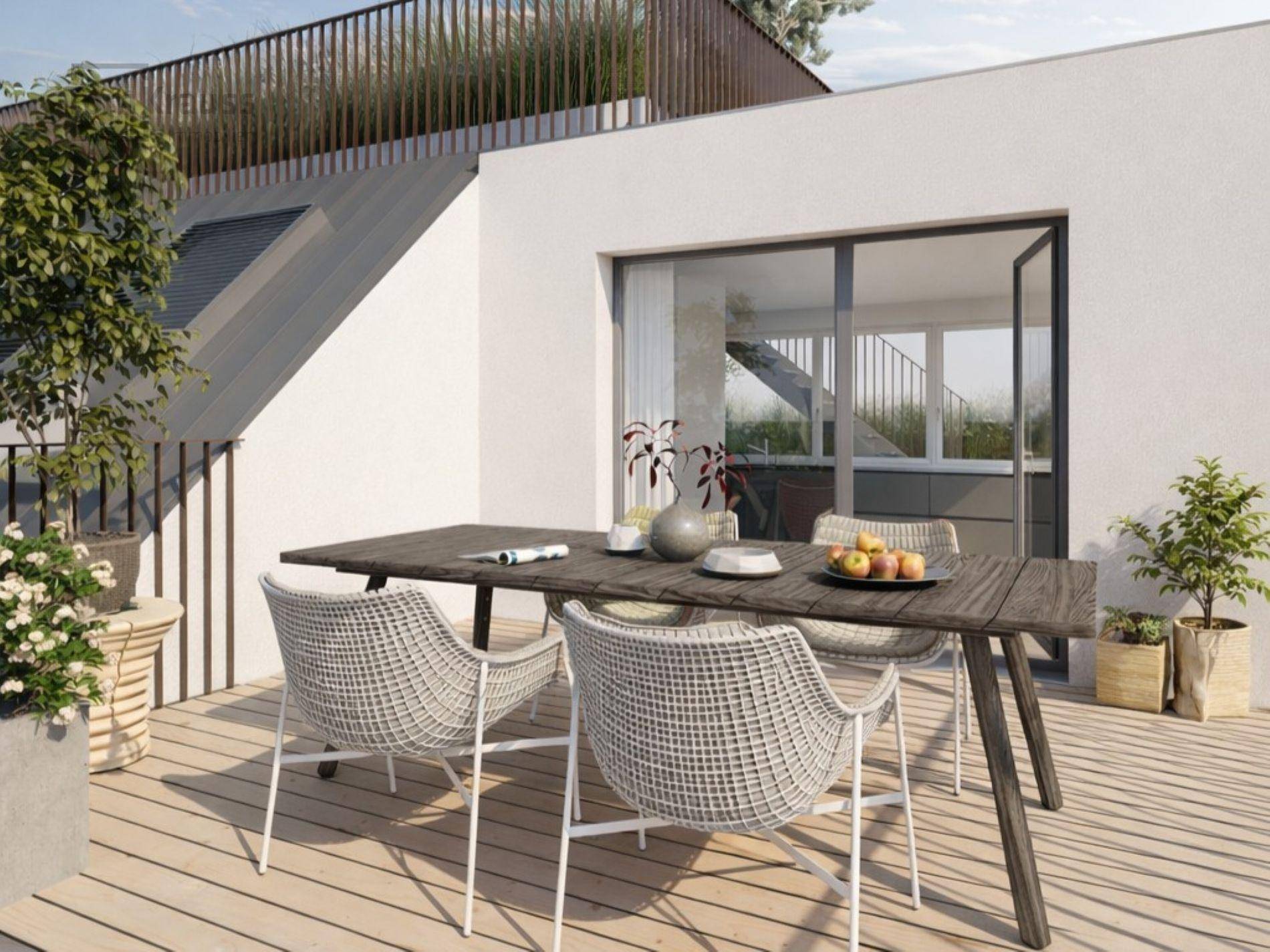 Gemütliche Terrasse mit Esstisch und Pflanzen, ideal für Mahlzeiten im Freien.