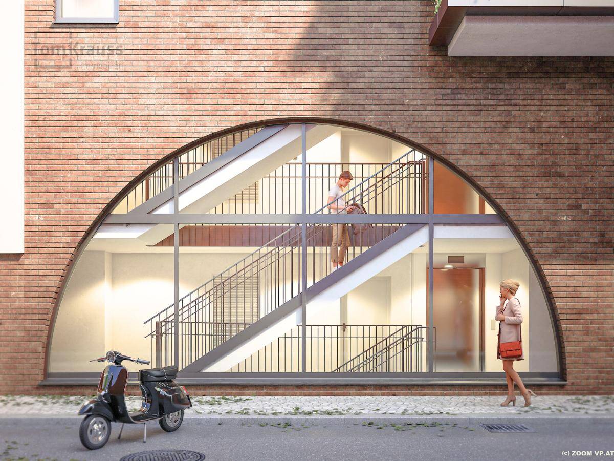Architektonisches Detail eines Treppenhauses hinter einem großen, bogenförmigen Fenster mit Ziegelfassade.