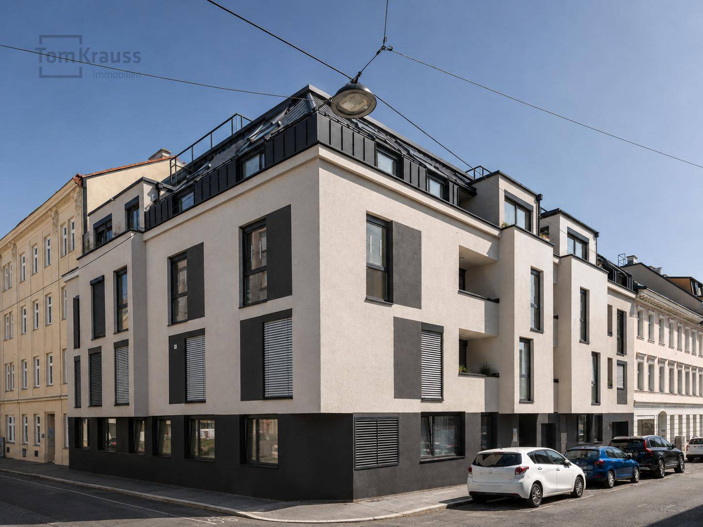 Eckansicht eines modernen Wohngebäudes mit zeitgenössischer Architektur und großen Fenstern.