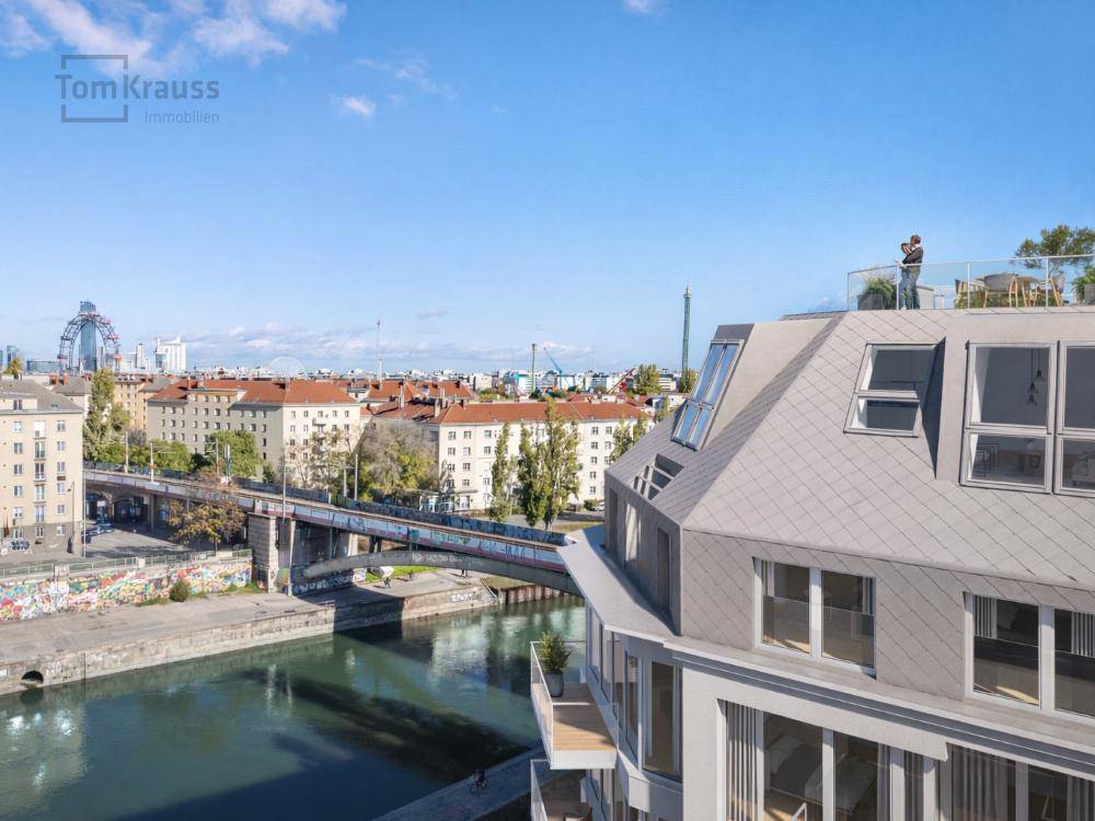 Modernes Wohngebäude am Flussufer mit Brücken und Stadtpanorama im Hintergrund.