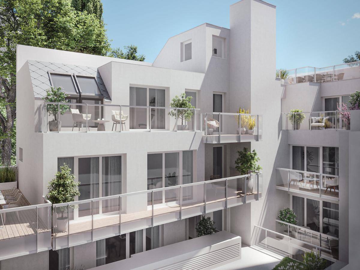 Ansicht eines modernen Wohngebäudes mit mehreren Balkonen und Dachterrassen in weißer Fassade.