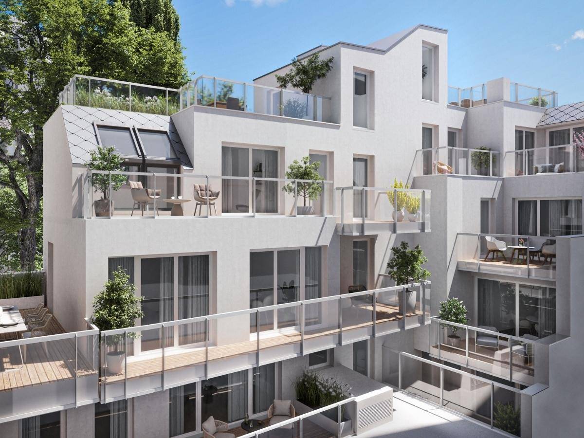 Moderne Architektur eines Wohngebäudes mit mehreren Terrassen und Balkonen unter blauem Himmel.