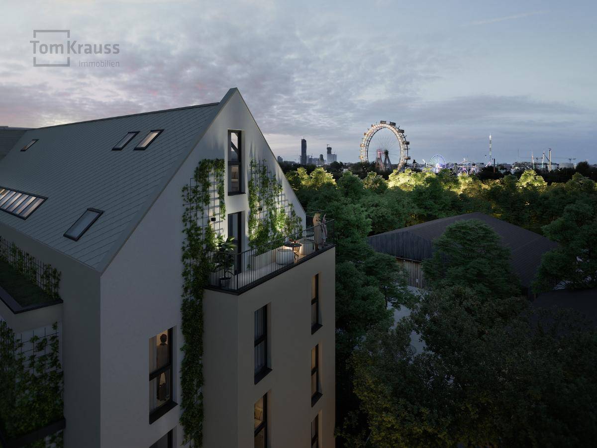 Dachterrasse des Gebäudes bei Dämmerung mit Blick auf das beleuchtete Riesenrad und die Stadt.