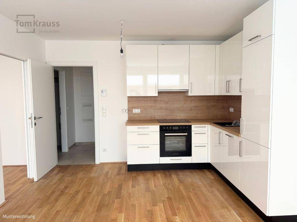 Moderne Einbauküche mit weißen Hochglanzfronten, Holz-Arbeitsplatte und integrierten Geräten.