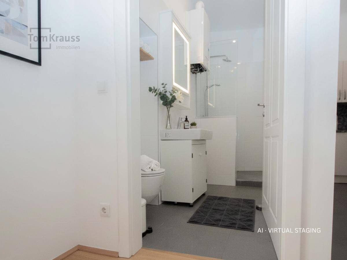 Virtuell inszeniertes modernes Badezimmer mit beleuchtetem Spiegel und Duschbereich.