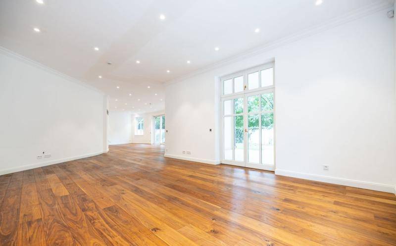 Heller Wohnraum mit Holzboden und großer Fenstertür, die viel Tageslicht hereinlässt.