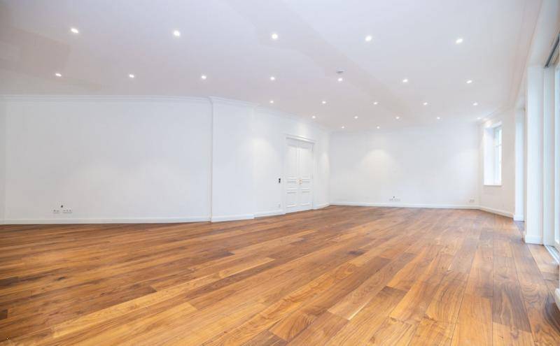 Großzügiger Wohnraum mit elegantem Holzboden und einer geschwungenen Wand.