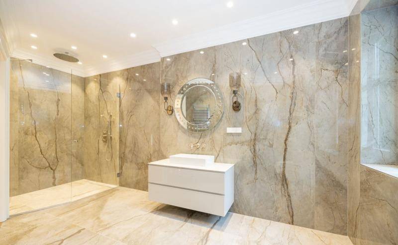 Modernes Badezimmer mit großformatigen Marmorfliesen, begehbarer Dusche und elegantem Waschtisch.
