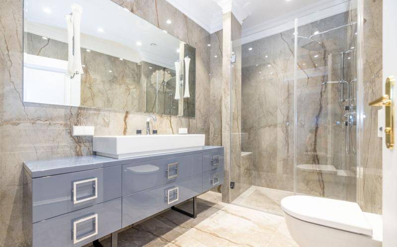 Stilvolles Badezimmer mit begehbarer Dusche, modernem Waschtisch und Marmorfliesen.