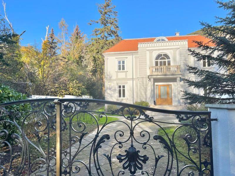 Detailansicht des kunstvollen schmiedeeisernen Tors, das den Eingang zur Villa markiert.