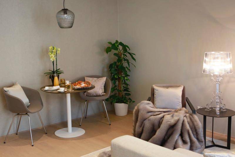 Gemütlicher Essbereich mit kleinem Tisch, bequemen Stühlen und dekorativer Orchidee.
