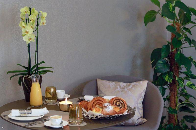 Nahaufnahme eines gedeckten Frühstückstisches mit frischen Backwaren und Orangensaft.