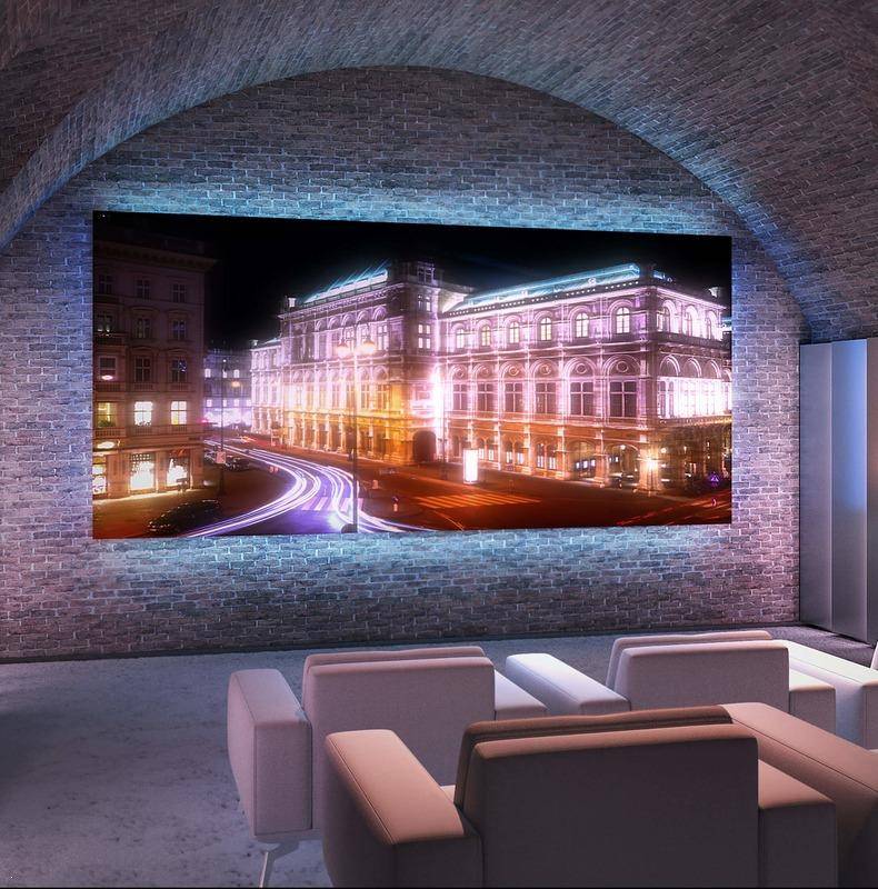 Gemütlicher Medienraum mit großer Leinwand, bequemen Sesseln und indirekter Beleuchtung in Gewölbeoptik.