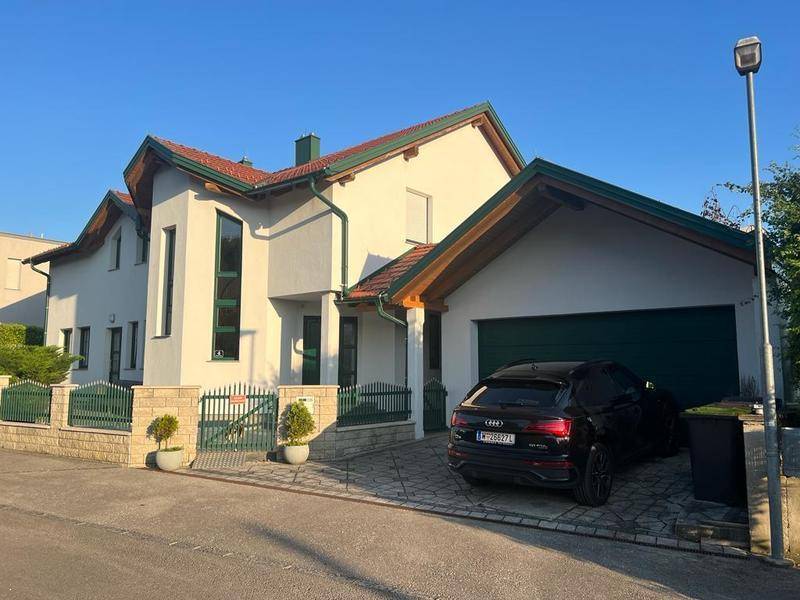 Ansicht des Hauses von der Straße mit Garage, Einfahrt und gepflegtem Vorgarten.