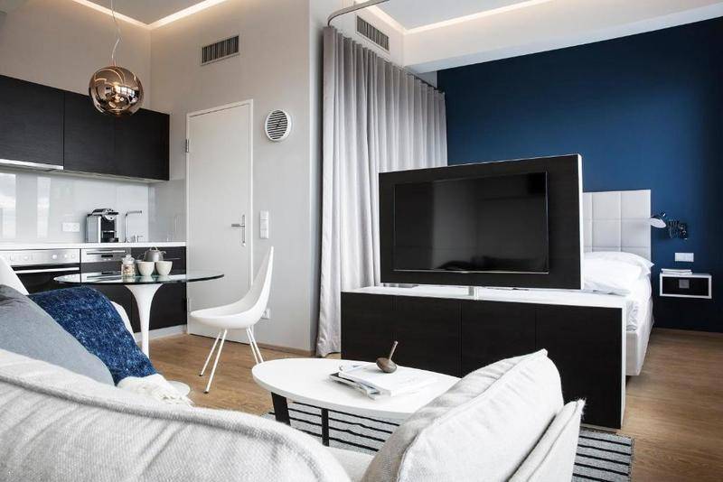 Offener Wohnbereich mit integrierter Küche, Essplatz und Schlafbereich in einem modernen Studio.