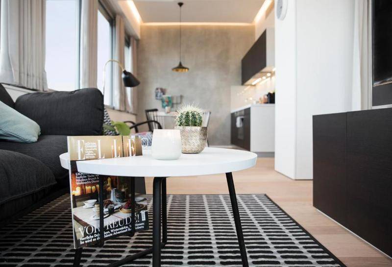 Gemütlicher Wohnbereich mit Sofa, Couchtisch und Blick auf die offene Küche.