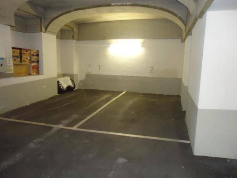 Tiefgaragenstellplatz mit Markierungen und einfacher Beleuchtung in einem Mehrfamilienhaus.