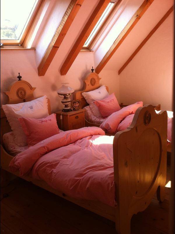 Helles Schlafzimmer im Dachgeschoss mit zwei Einzelbetten und Dachfenstern.