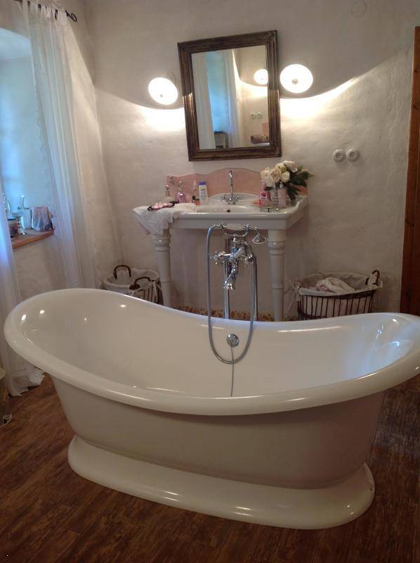 Elegantes Badezimmer mit freistehender Badewanne und klassischem Waschtisch.