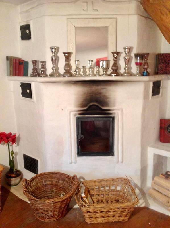 Traditioneller Kamin mit Kaminsims, dekoriert mit Kerzenständern und Büchern.