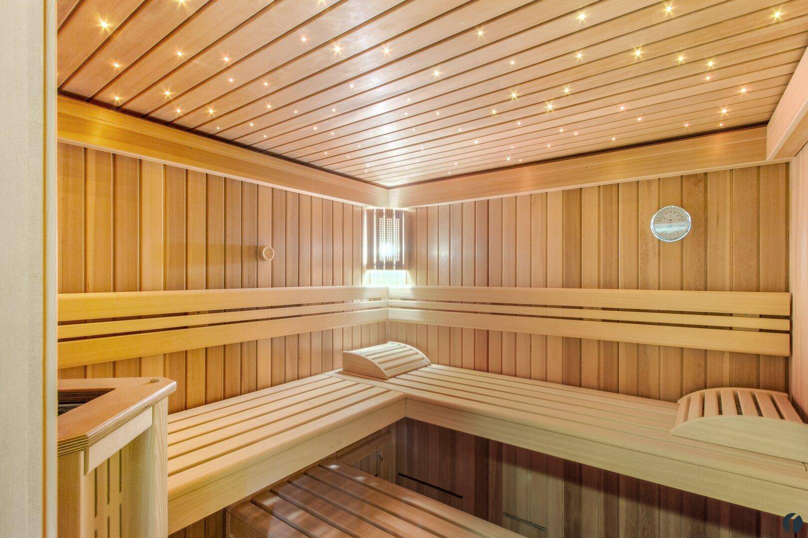 Geräumige Holzsauna mit mehreren Bänken und stimmungsvoller Sternenhimmelbeleuchtung.