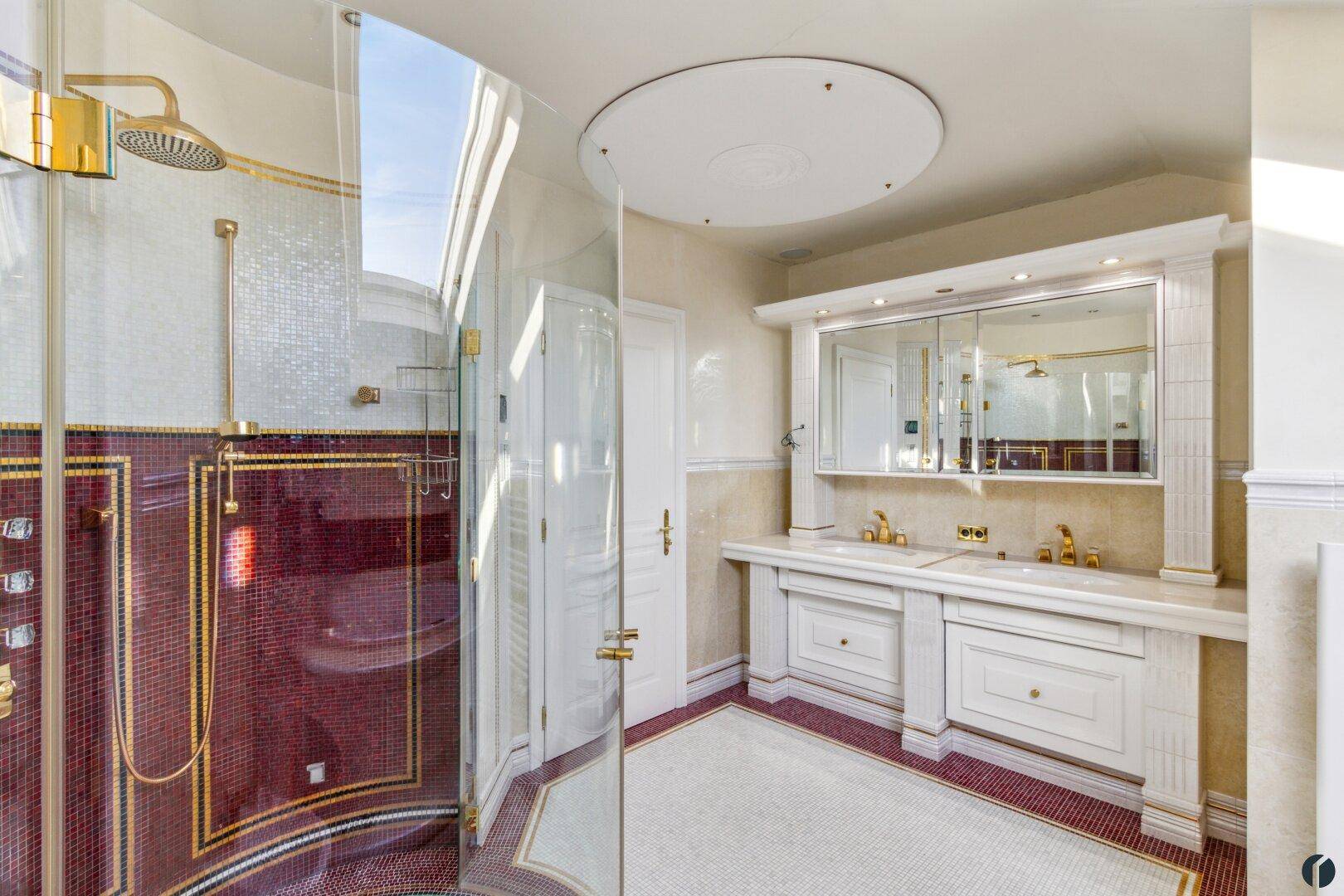 Luxuriöses Badezimmer mit Doppelwaschbecken, großer Dusche und aufwendigen Mosaikfliesen.