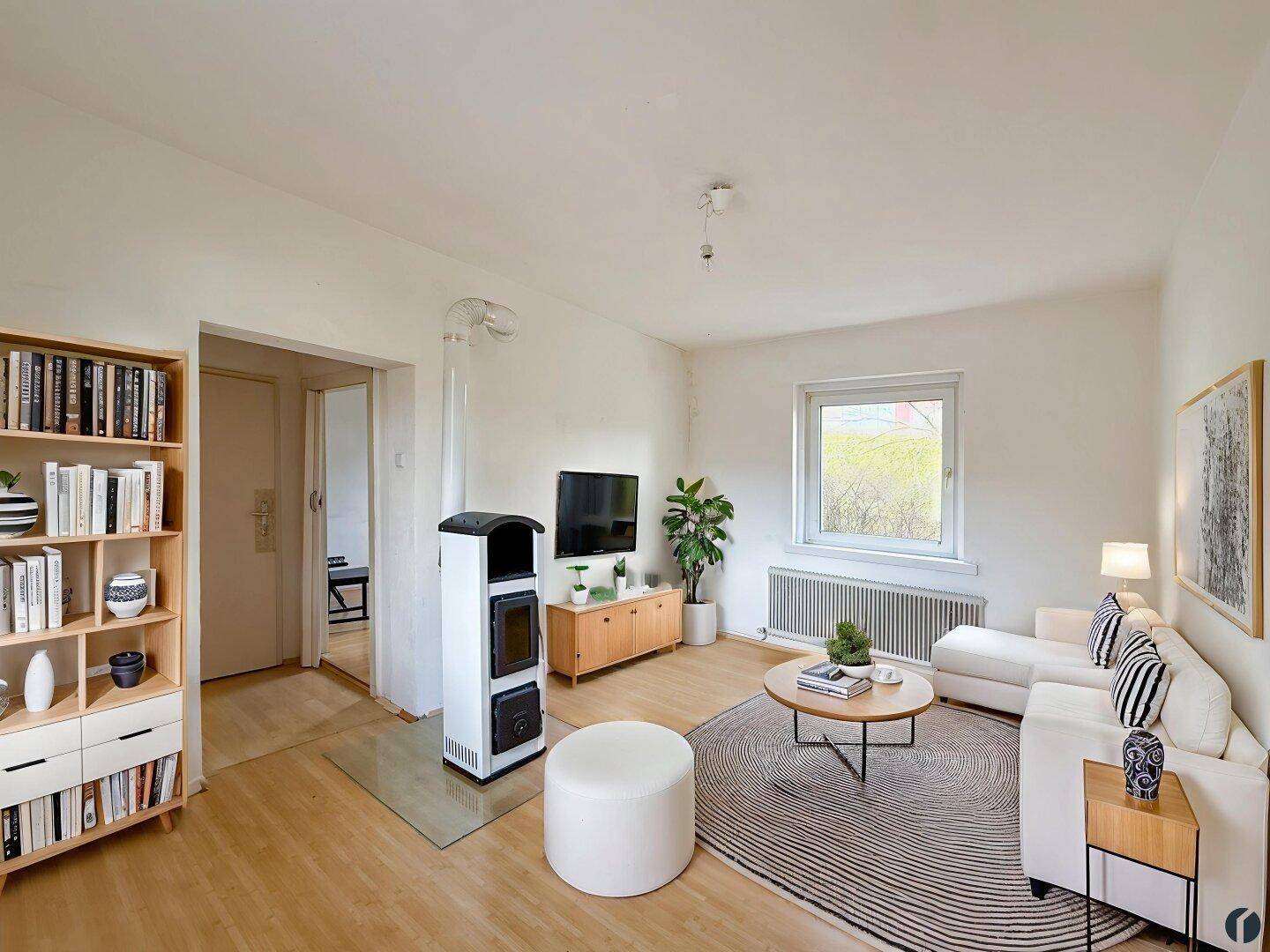 Helles Wohnzimmer mit modernem Kaminofen, Parkettboden und gemütlicher Sitzecke.