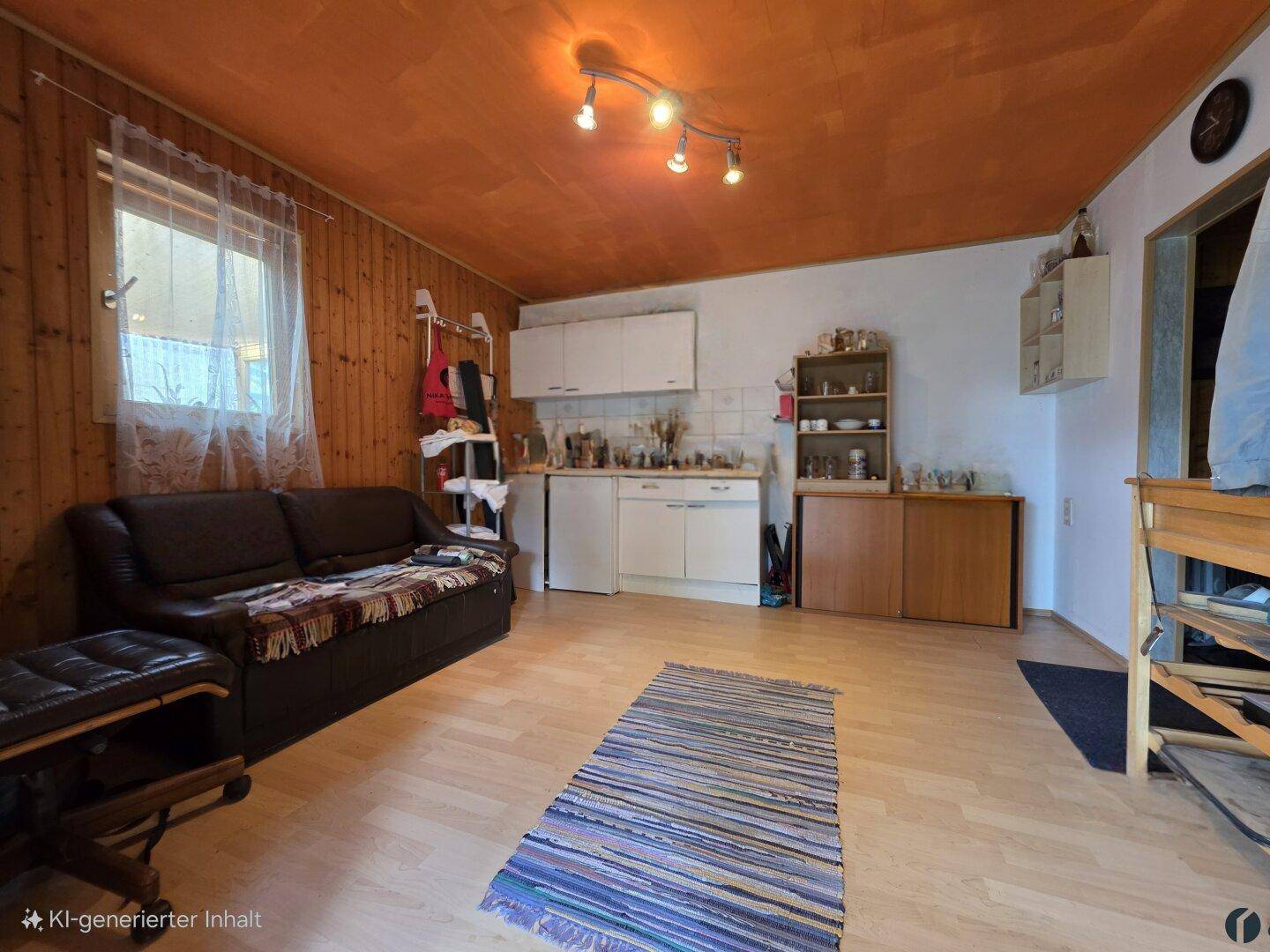Kombinierter Wohnbereich mit kleiner Küchenzeile, Holzvertäfelung und einer auffälligen orangefarbenen Decke.