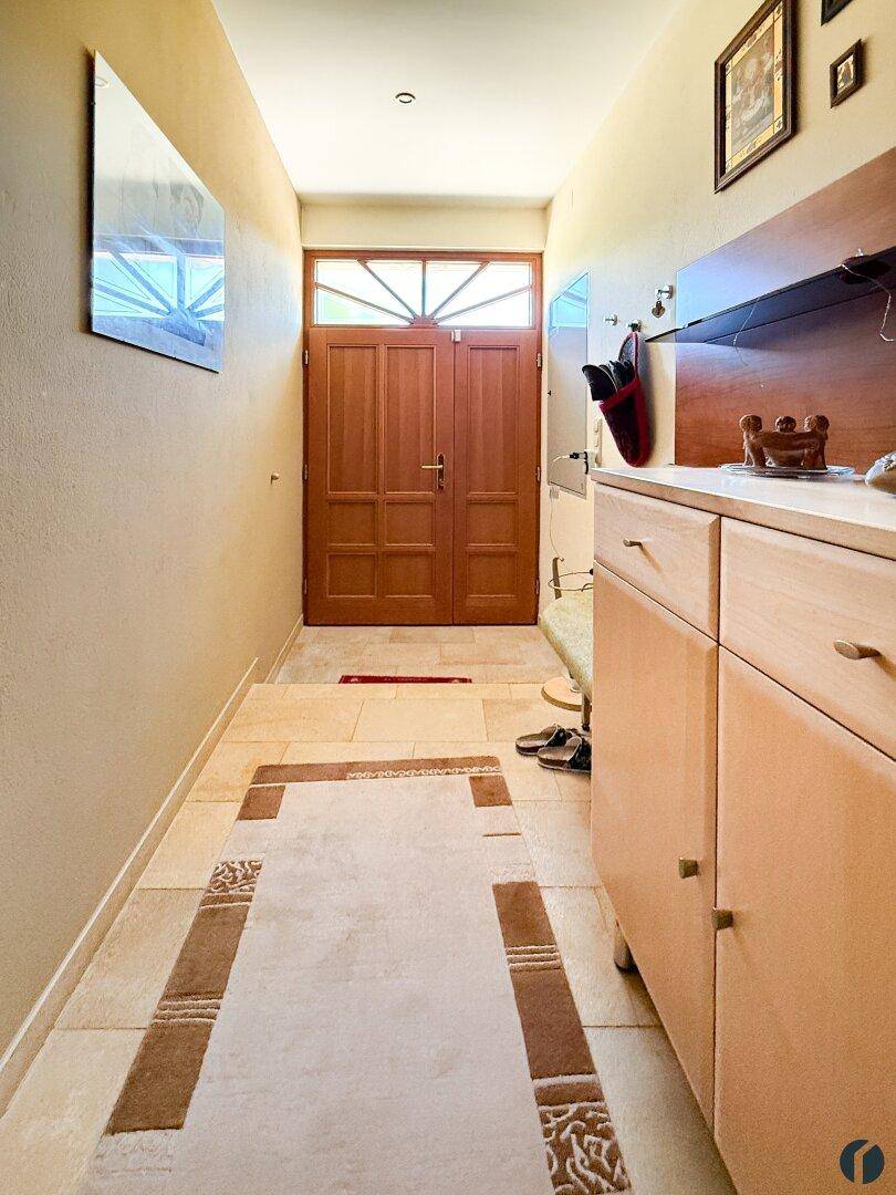 Heller Eingangsbereich mit Fliesenboden, Holztür und praktischem Garderobenschrank.