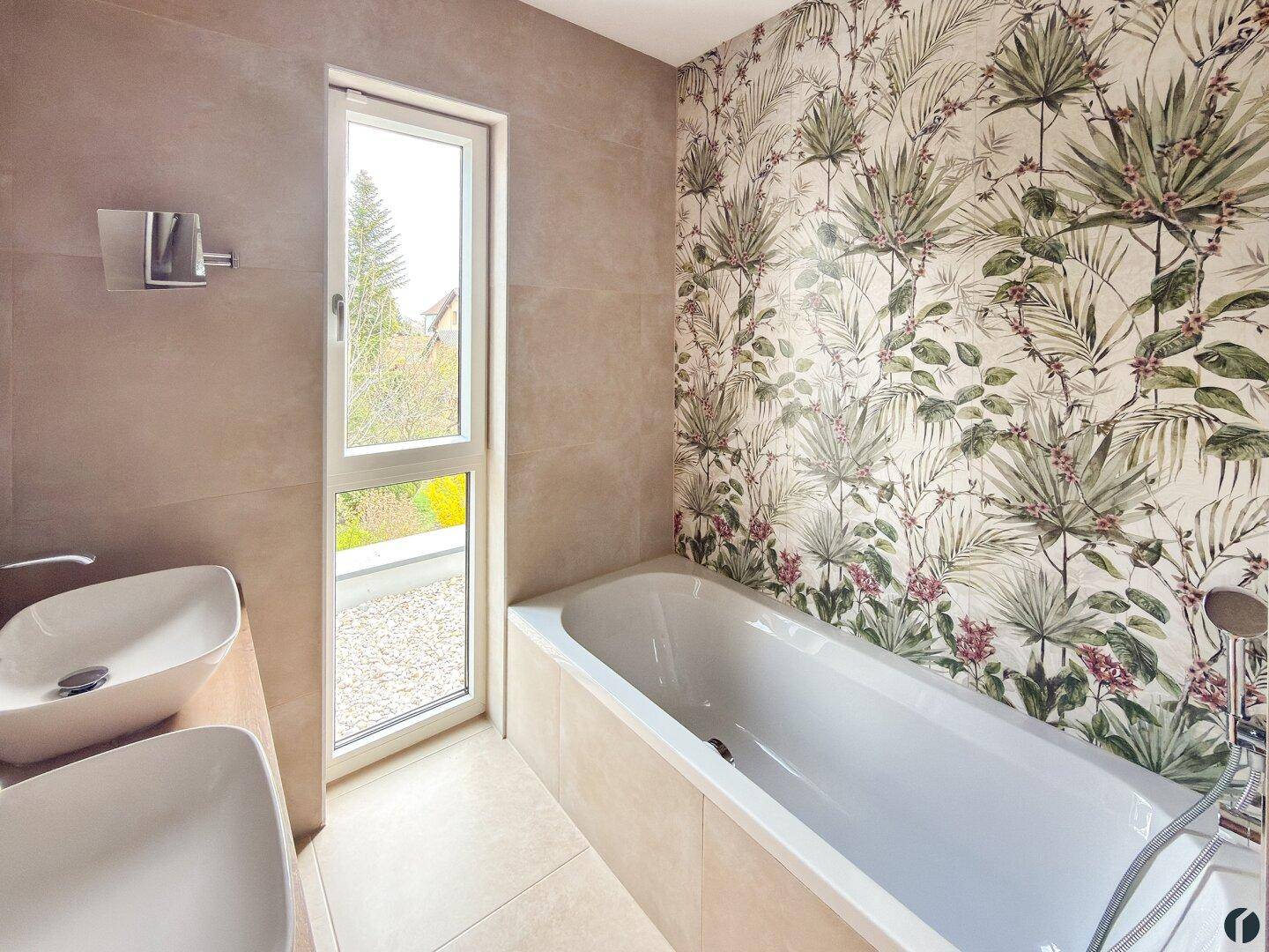 Badezimmer mit Badewanne, floraler Tapete und Fenster für natürliches Licht.
